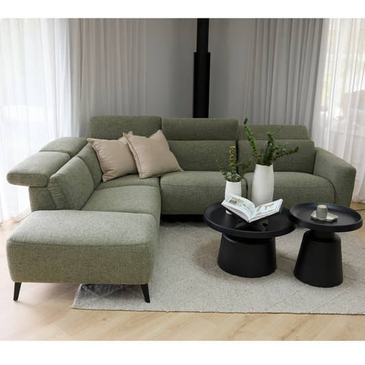 Green sectional sofa with beige cushions in a living room setting.